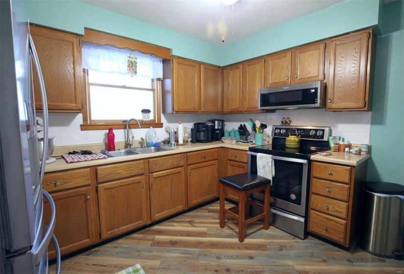 Kitchen with sink, appliances with stainless steel finishes, and light wood-type flooring