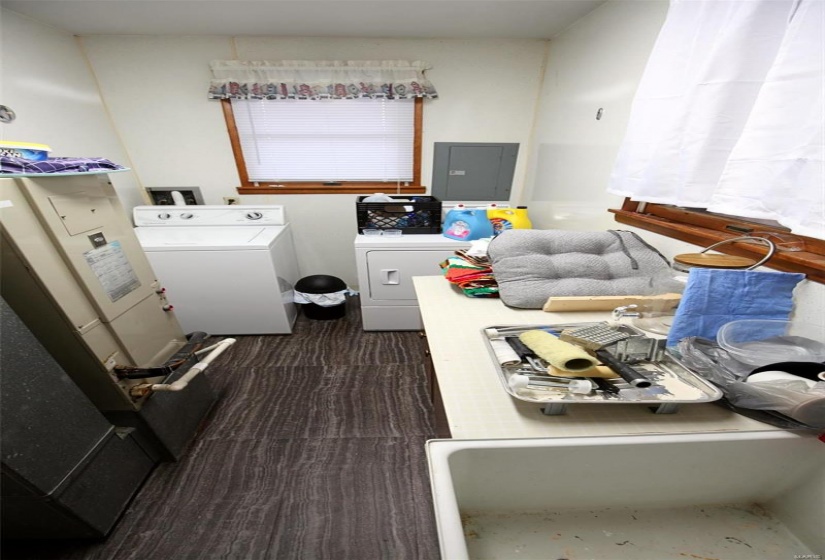 Laundry area featuring electric panel and washing machine and dryer