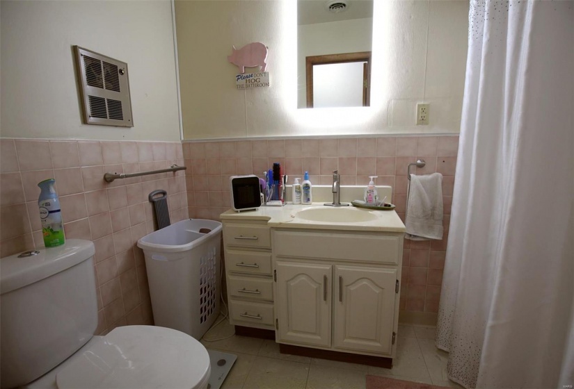 Bathroom featuring tile walls, toilet, vanity, and tile patterned flooring