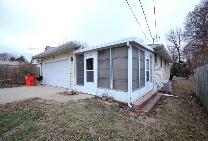 View of home's exterior with cooling unit, a garage, and a yard