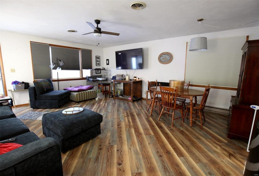 Living room with ceiling fan, a baseboard heating unit, and dark hardwood / wood-style flooring