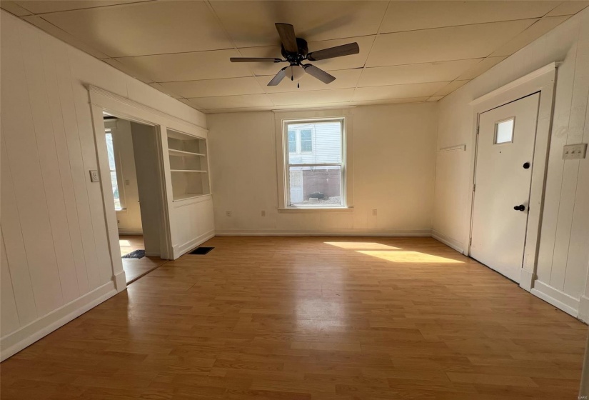Spare room with baseboards, light wood-type flooring, visible vents, and a ceiling fan